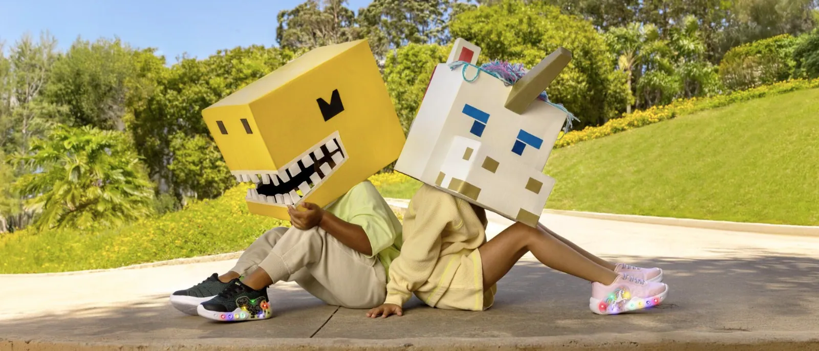 Two kids with playful block-head costumes wearing Bibi light-up trainers